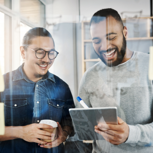 Two smiling men looking at data on ipad