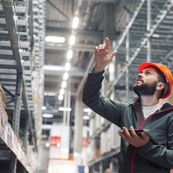 Man looking up at tall shelves