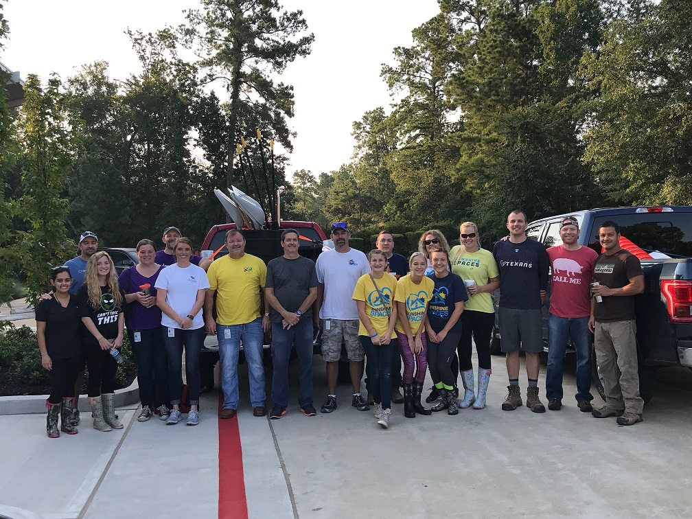 Group of people in a parking lot standing in front of trucks