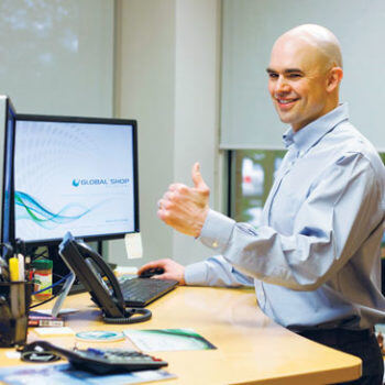 Man standing at desk giving a thumbs up