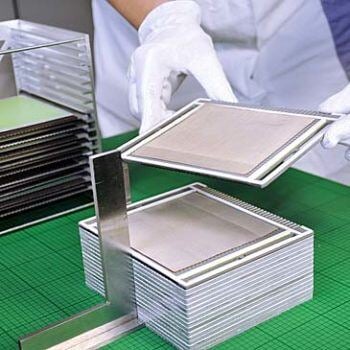 Hands stacking metal sheets
