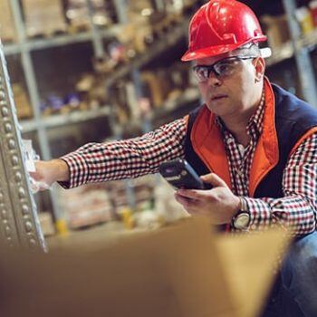 Man in hard hat looking at shelves