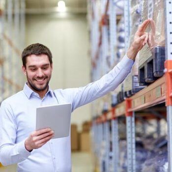 Man reaching for something on a shelf in a warehouse