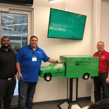 People standing by tiny green ambulance