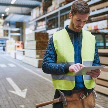 Man in warehouse holding iPad