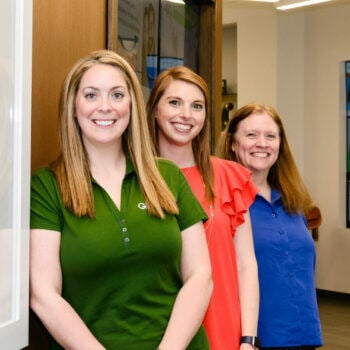 Three women leaning against a wall