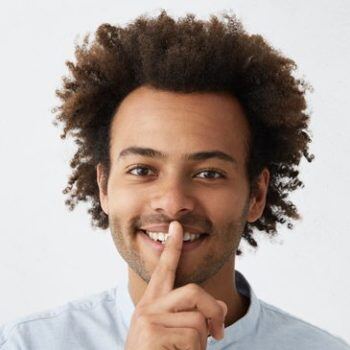Man looking at camera shushing it