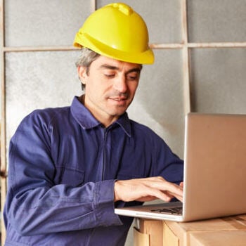 Man in hardhat working on laptop