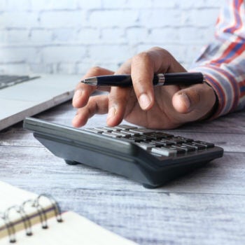 Hands touching a calculator