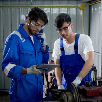 Two manufacturers with one holding an iPad