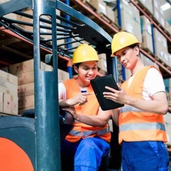 Two people looking a clipboard in warehouse