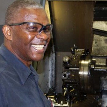 Man smiling next to machine