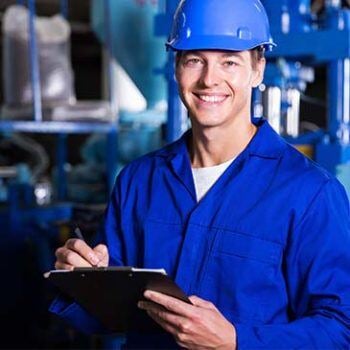 Man in coveralls and hardhat smiling