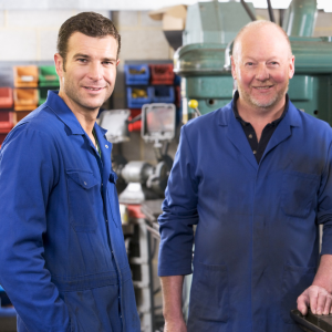 Two male manufacturers smiling on a shop floor