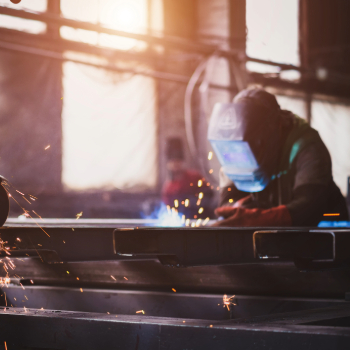 man welding on metal with sparks flying