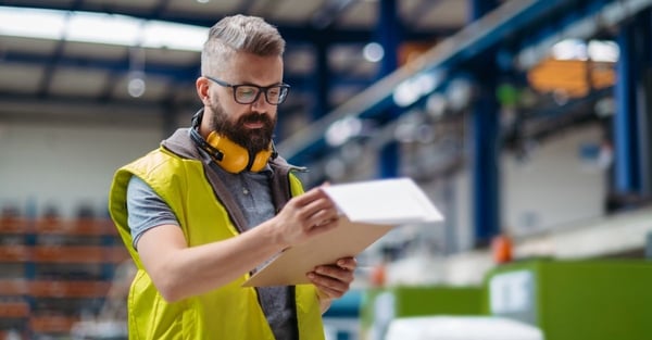 Shop floor worker looking at clipboard