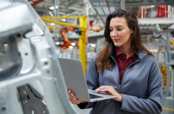 Female manufacturer using laptop on shop floor