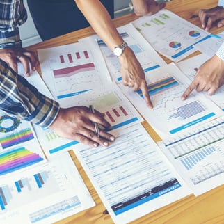 Colleagues pointing at financial paper reports