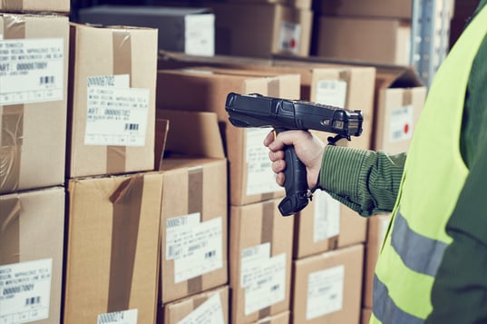 man-in-safety-vest-using-paperless-warehouse-management-system