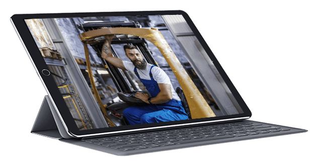Image in an iPad of enthusiastic manufacturing worker on a forklift