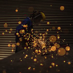 female worker welding with sparks flying